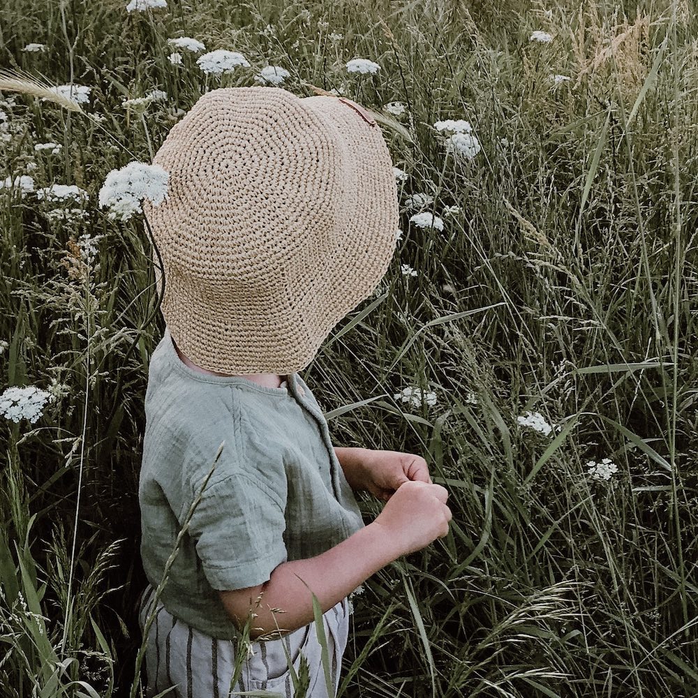 Hā Naturally image of child with natural hat in field - brand image for NZ distributor of lifestyle brands